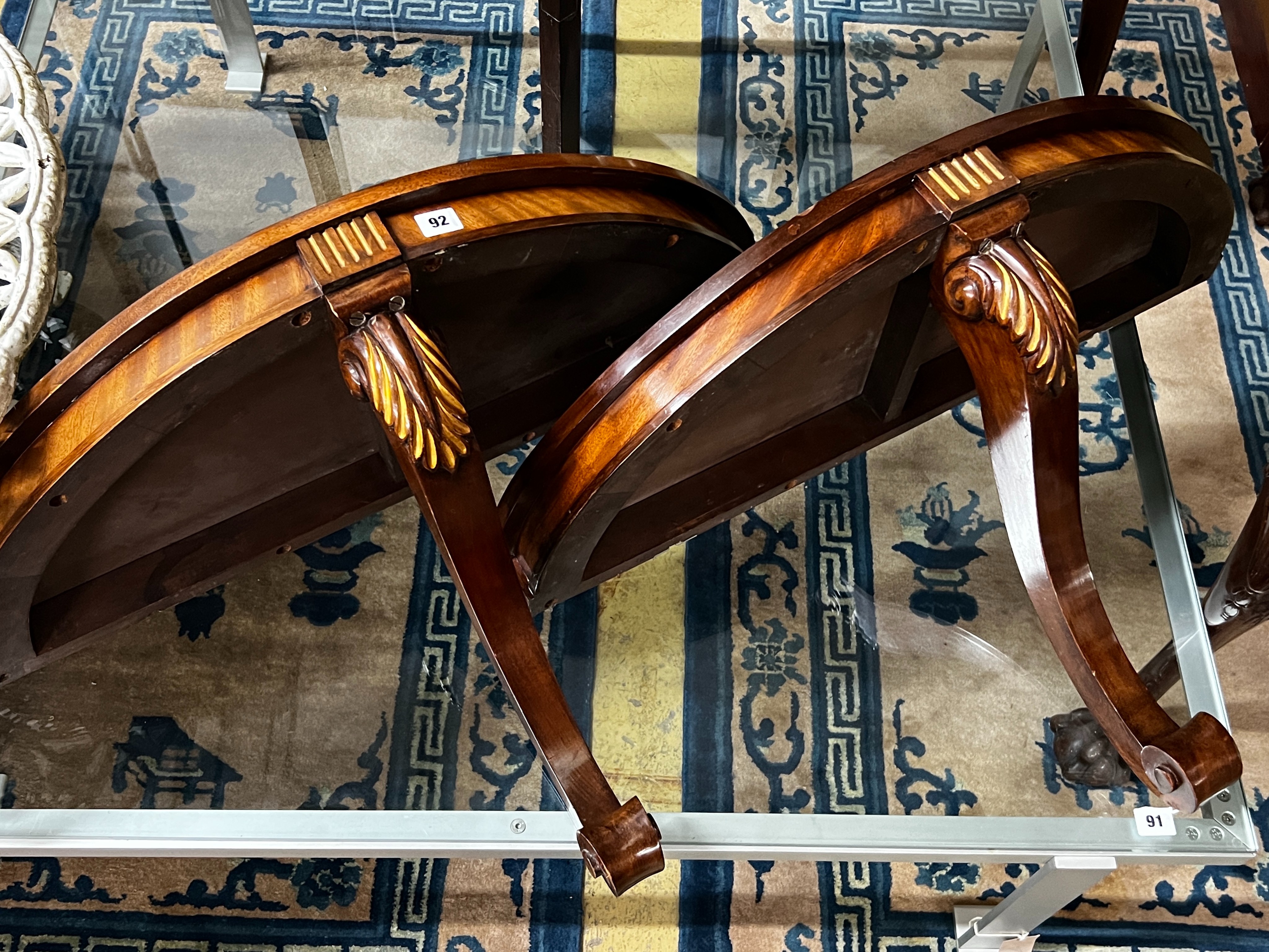 A pair of reproduction parcel gilt demi lune console tables, width 82cm, depth 34cm, height 48cm